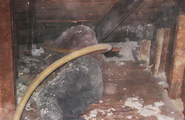 Insulation is added to the walls from the attic. Yes, that is a person lying on the floor.